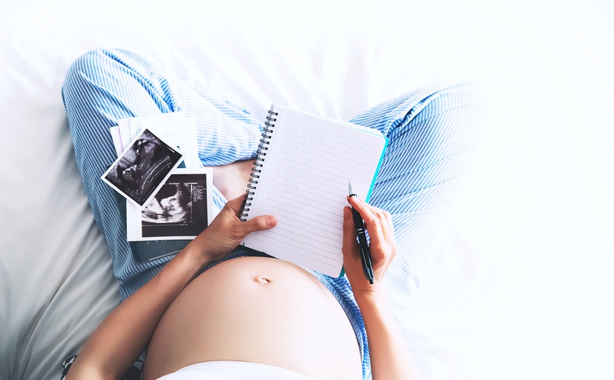femme enceinte avec échographie et bloc note